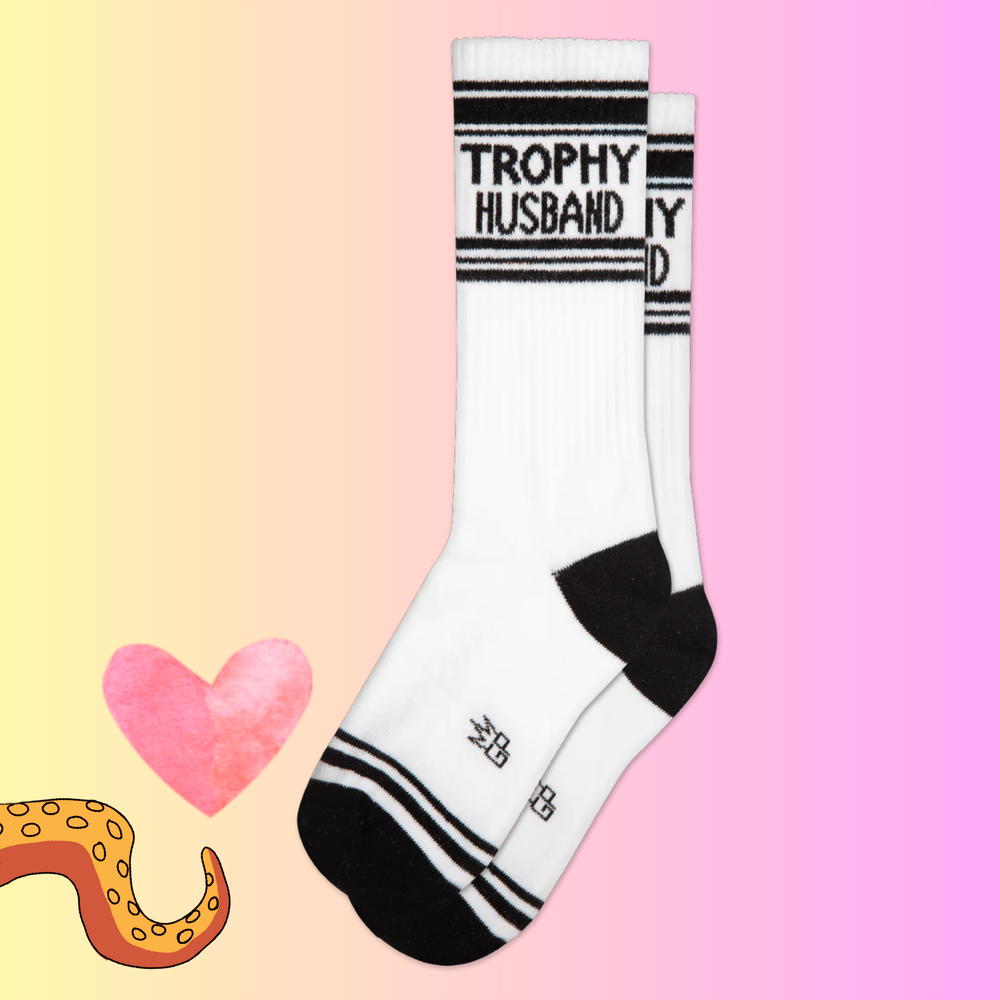 A pair of black and white sports style socks with a Trophy Husband slogan. 