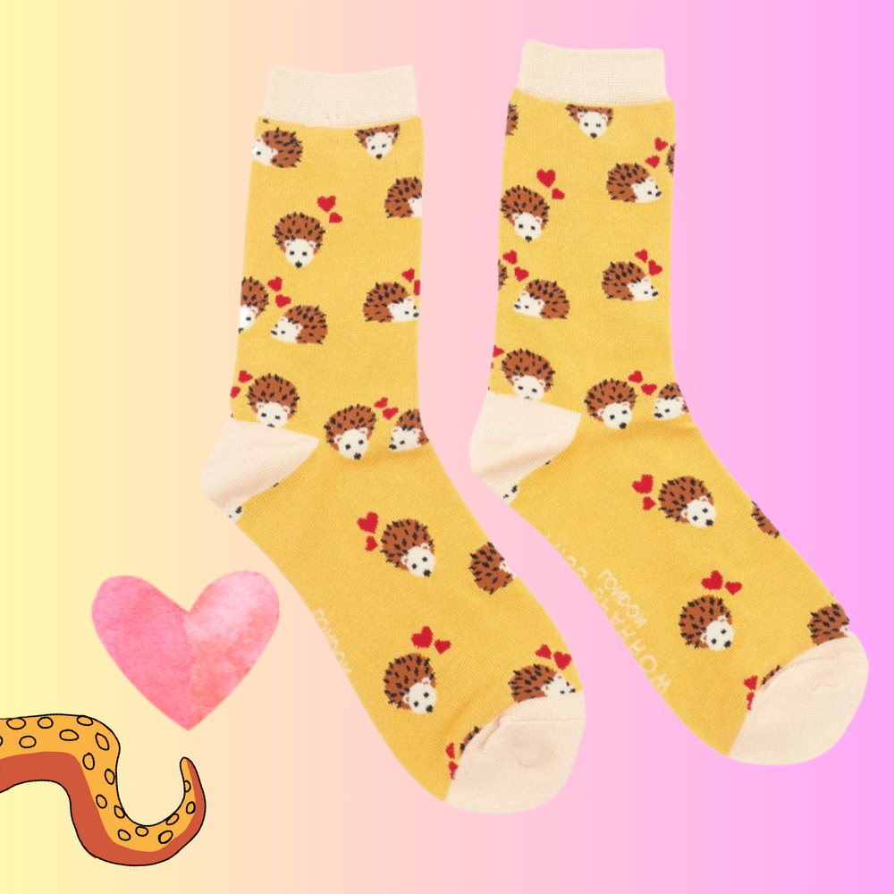 
                      
                        A pair of socks with a hedgehog and hearts motif. Yellow legs, pink heel, toe and cuff. 
                      
                    