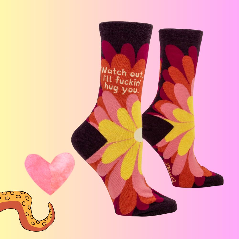 A pair of socks that have a flower motif and a sweary slogan. 