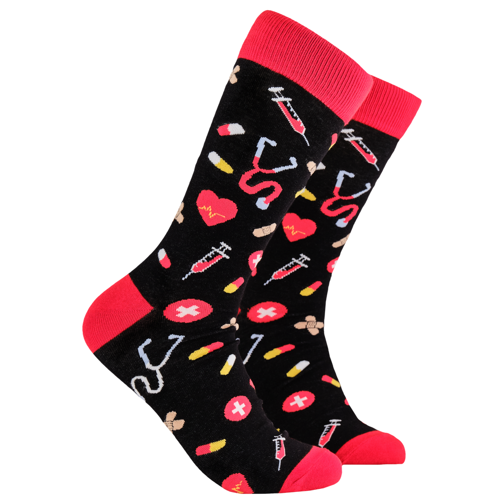 
                  
                    A pair of socks depicting medical equipment and symbols. Black legs, red cuff, heel and toe.
                  
                