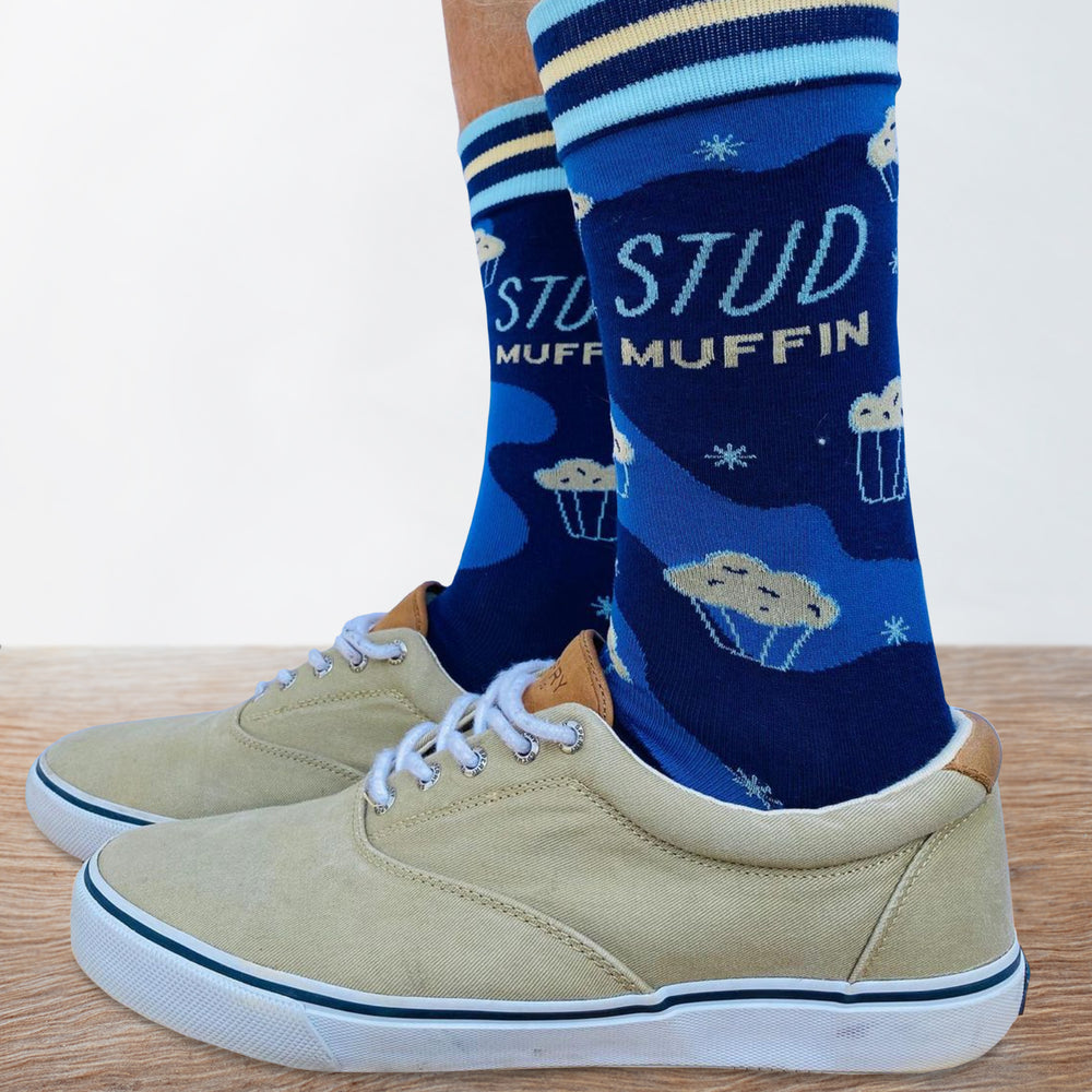 
                      
                        A model wearing a pair of socks with a stud muffin slogan. Blue legs, light blue heel, toe and cuff. 
                      
                    