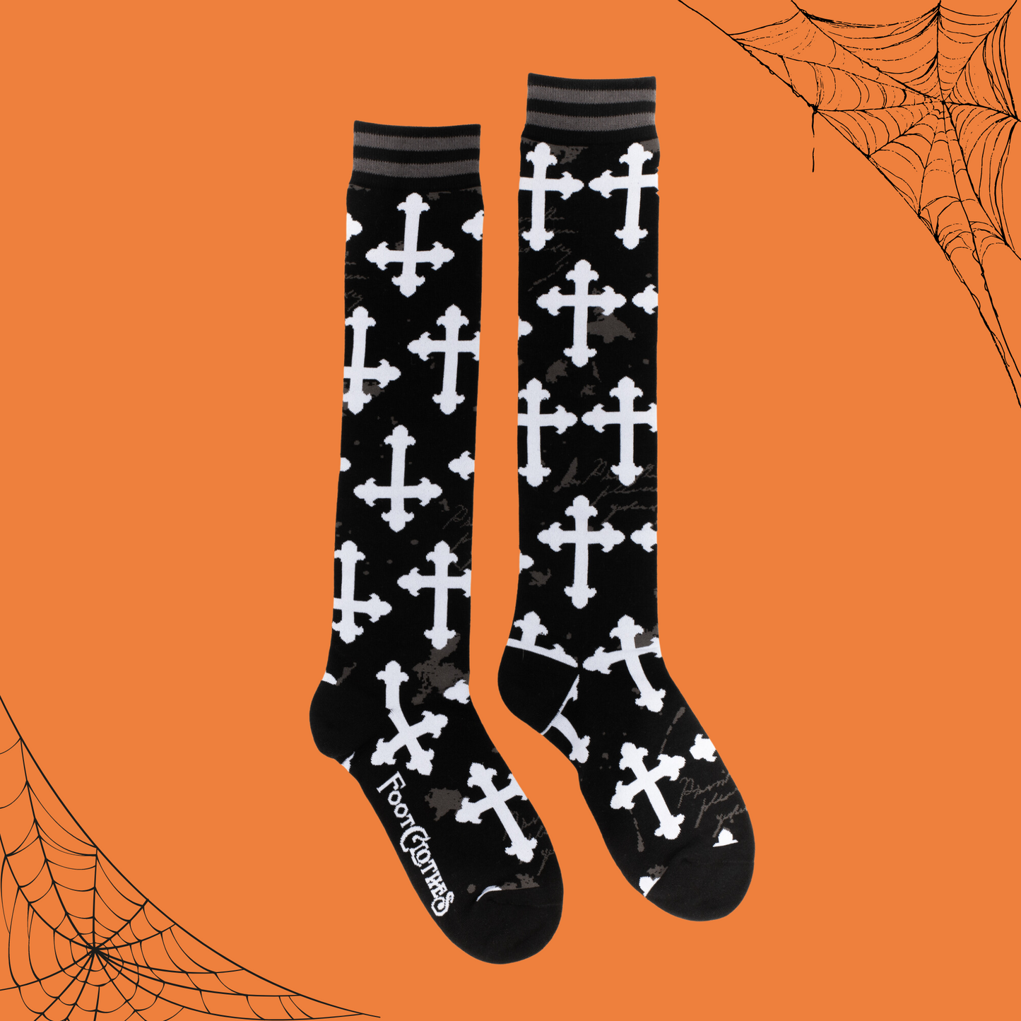 
                  
                    A pair of knee high socks with a gothic cross pattern. Black and white. 
                  
                