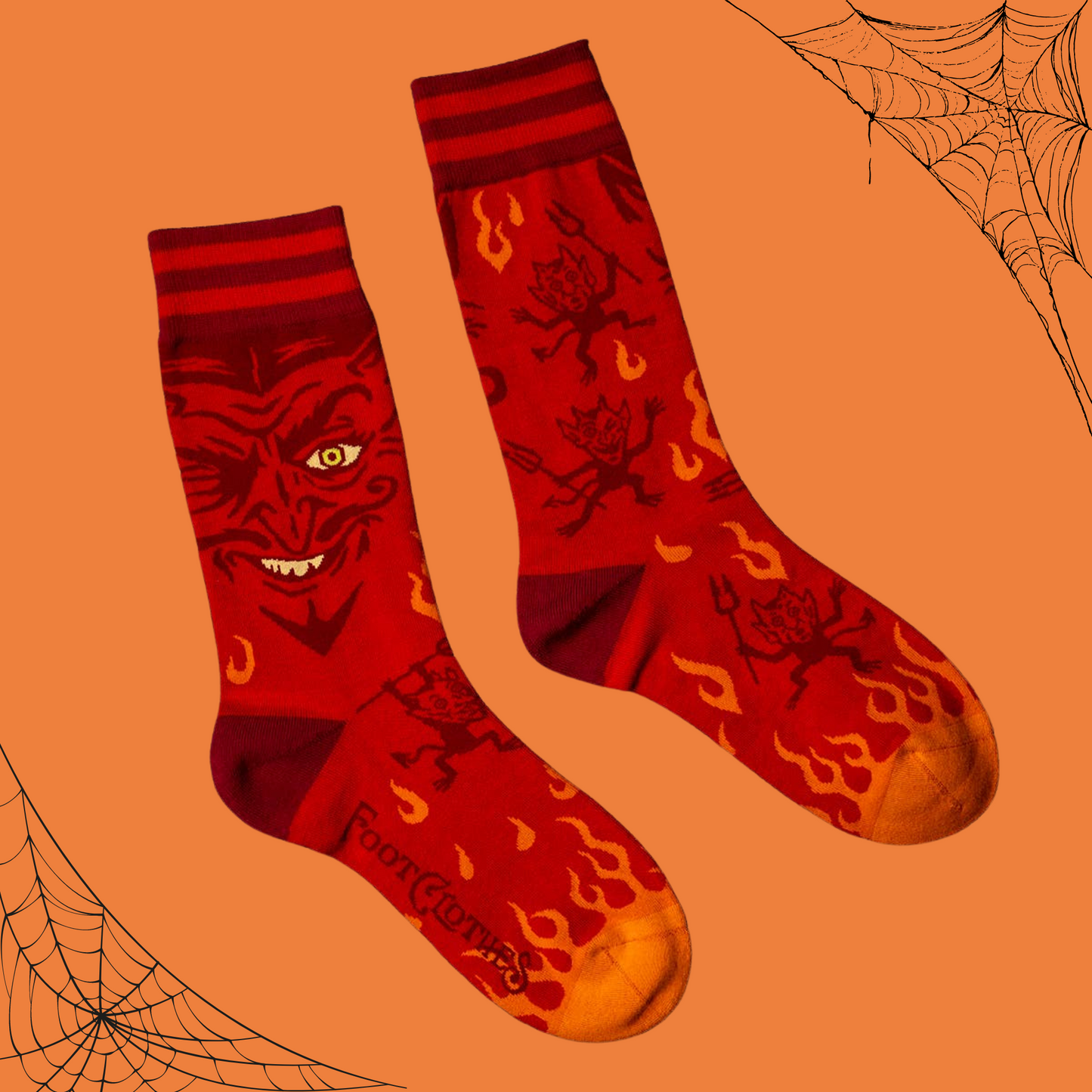 
                  
                    A pair of socks inspired by vintage magic posters with a picture of the devil. Orange flame toes, red heel and cuff. 
                  
                