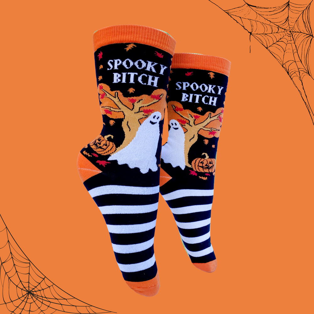 A pair of socks depicting a selection of halloween items. Black and white legs, orange toe, cuff and heel. 