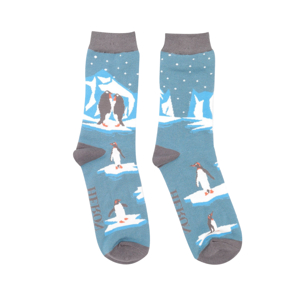 
                      
                        A pair of socks depicting penguins on ice. Blue legs. Grey blue toes, heel and cuff. 
                      
                    