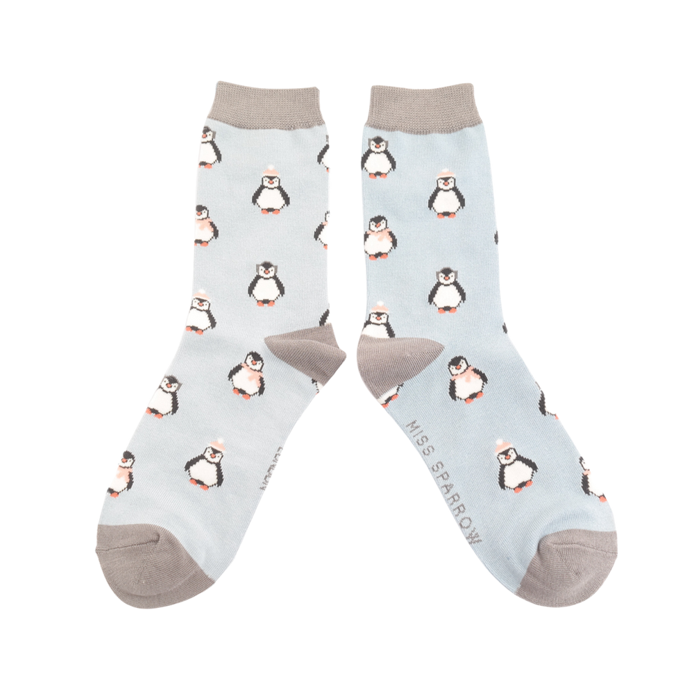 
                      
                        A pair of socks depicting penguins wearing hats and scarves for the winter. Light legs, grey toes, heels and cuffs. 
                      
                    