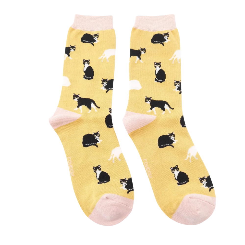 
                      
                        A pair of socks featuring black and white cats. Yellow legs, cream heel, toe and cuff. 
                      
                    