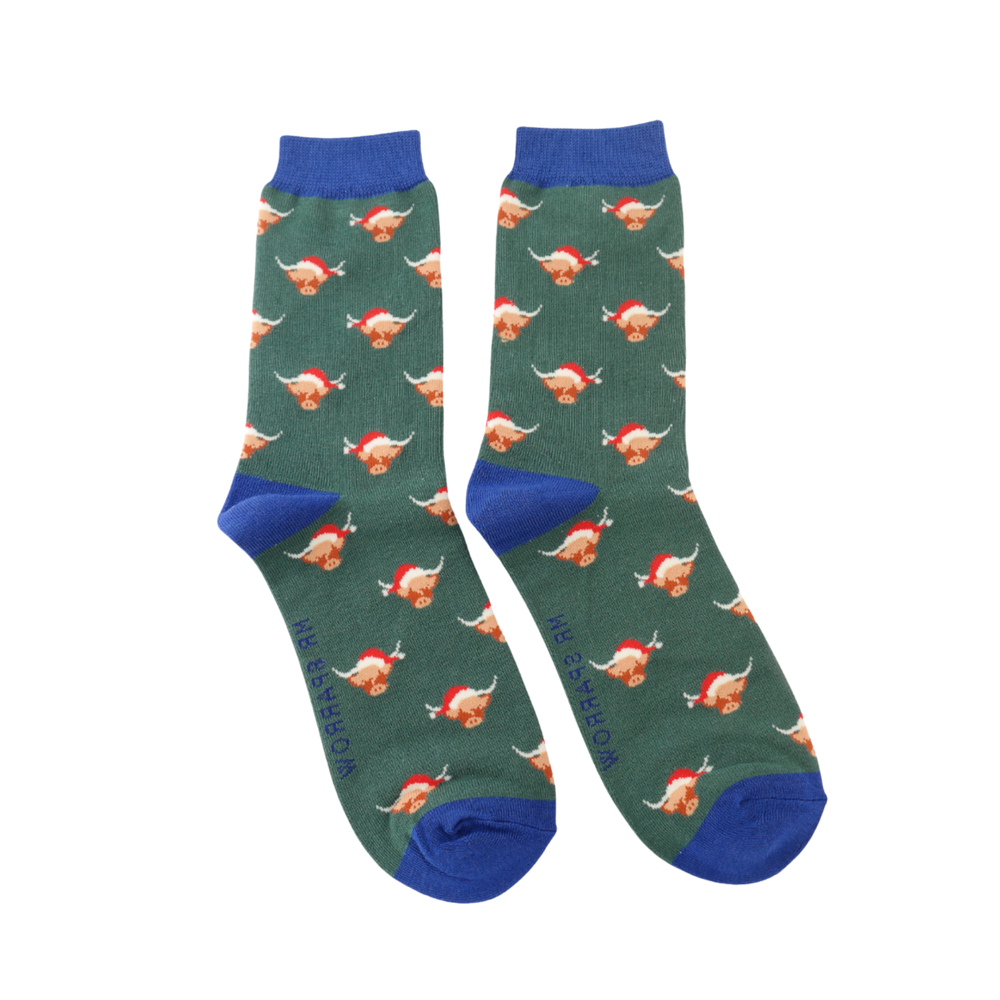 
                      
                        A pair of socks with a festive highland cow pattern. Dark green legs, blue heel, toe and cuff. 
                      
                    