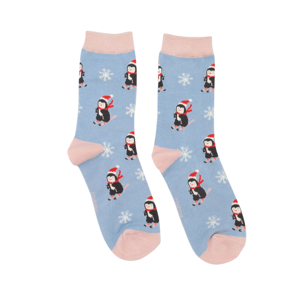 Skiing Penguins Bamboo Socks - Miss Sparrow. A pair of socks depicting skiing penguins and a snowflake pattern. Blu legs. Pink heel toe and cuff. 