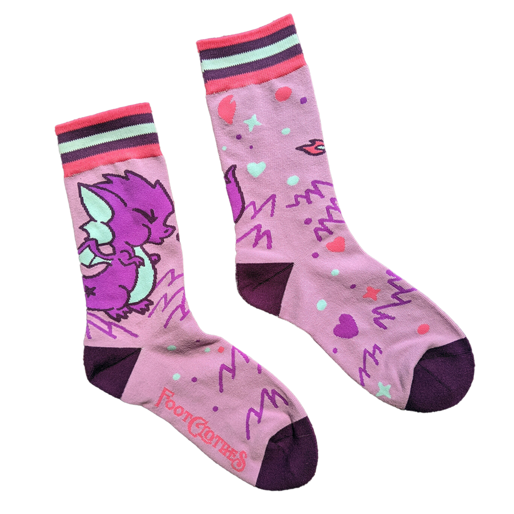 
                      
                        Cute Dragon Socks. A pair of socks featuring a cute dragon motif. Pink legs, purple heel, toe and cuff. 
                      
                    