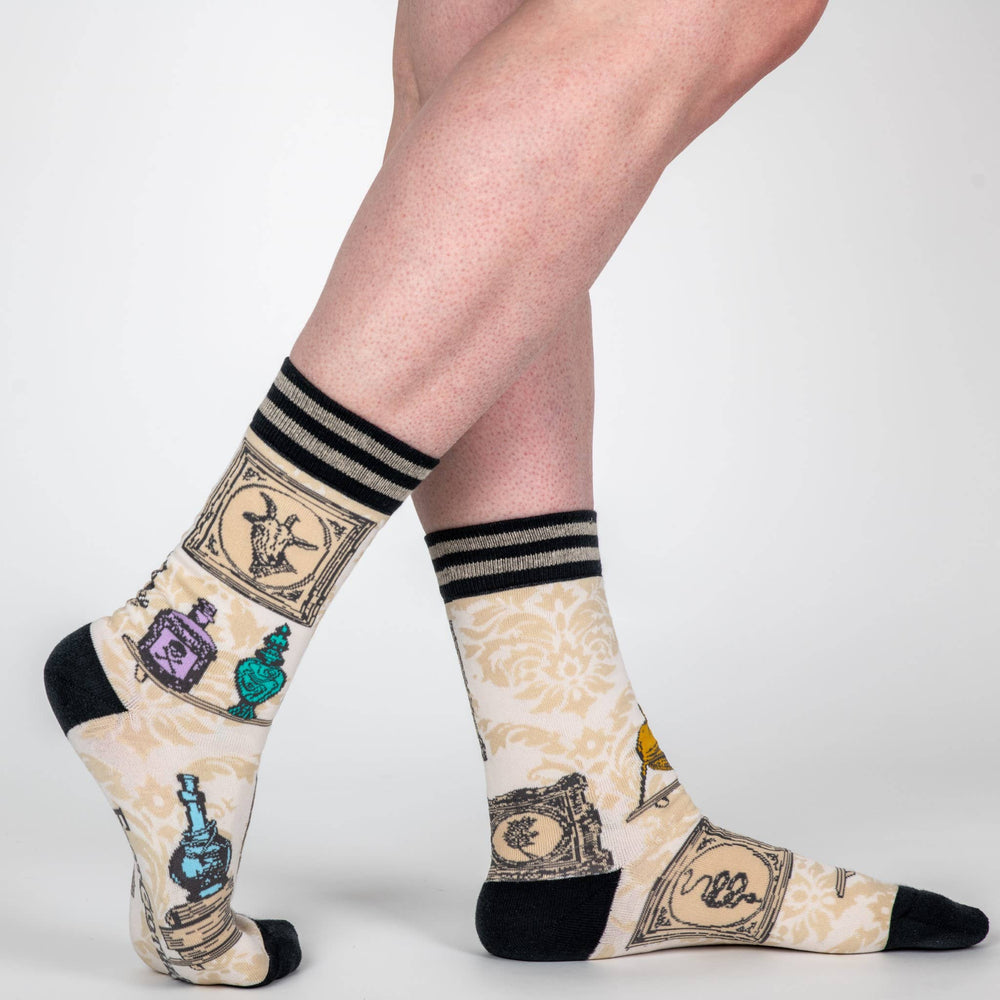 
                      
                        A pair of socks featuring antique curiosities. Cream legs, black heel, toe and cuff. 
                      
                    