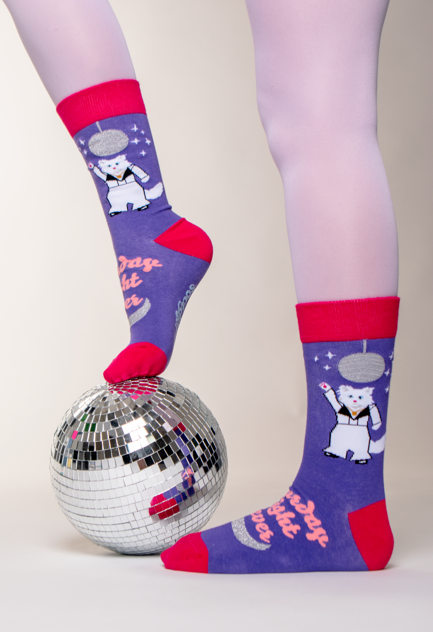 A model wearing a pair of disco cat Soctopus socks and a mirror ball. 