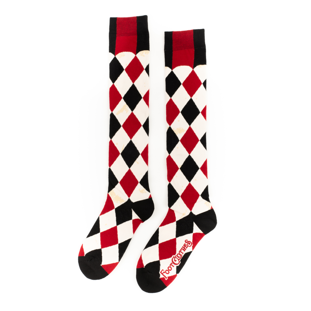 
                      
                        A pair of knee high socks with a harlequin pattern. Black, white and red. 
                      
                    