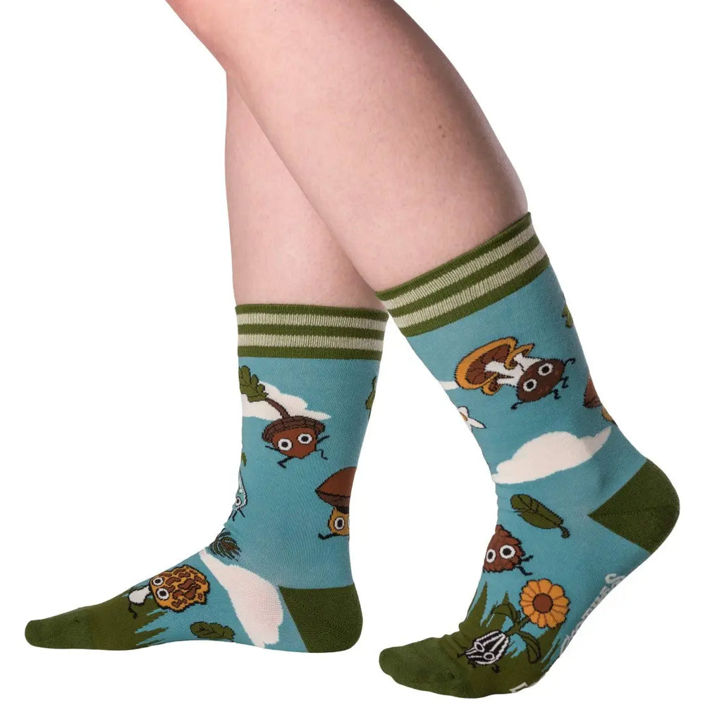 
                      
                        A model wearing a pair of socks depicting cute woodland creatures. Bright blue legs, green heel, toe and cuff. 
                      
                    