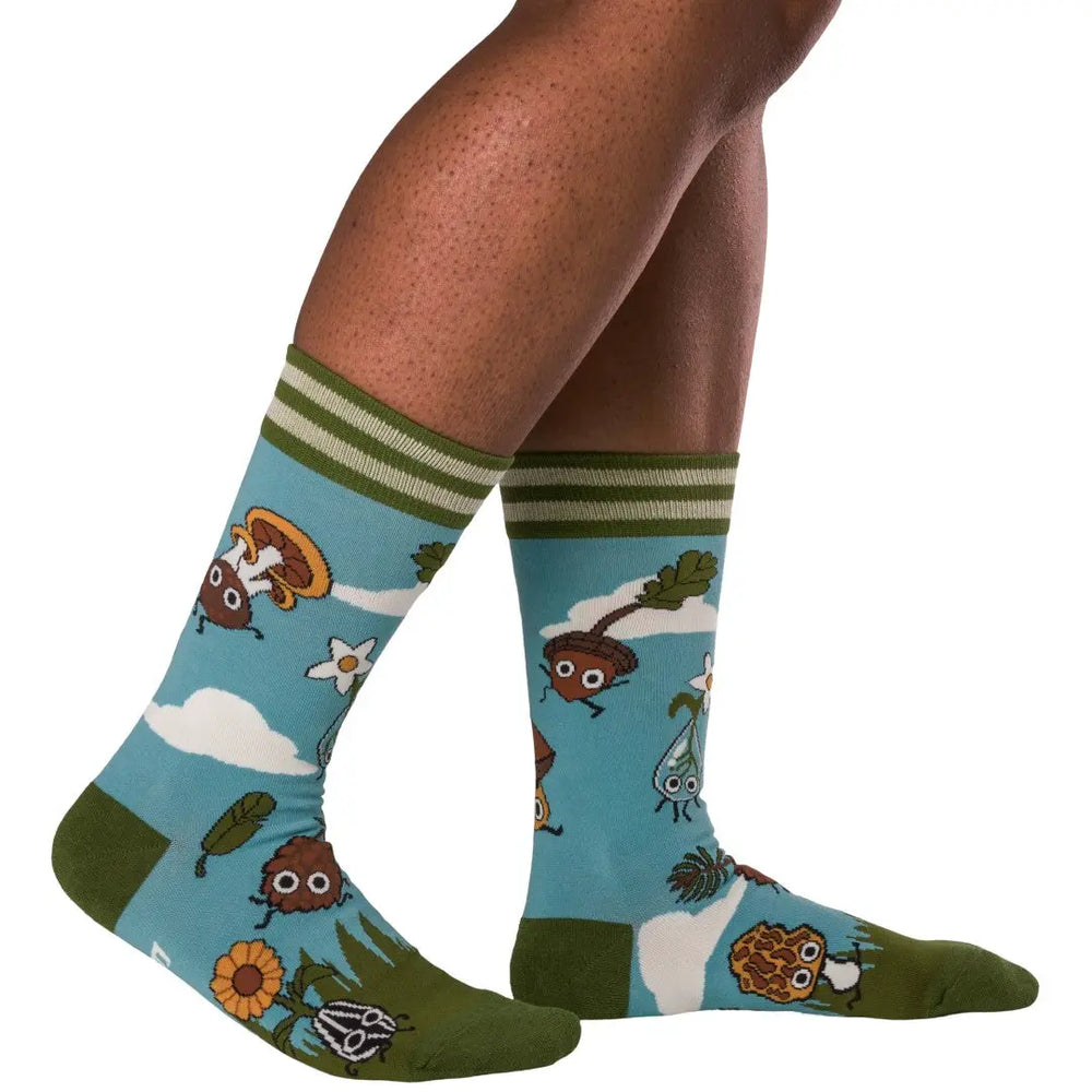 
                      
                        A model wearing a pair of socks depicting cute woodland creatures. Bright blue legs, green heel, toe and cuff. 
                      
                    